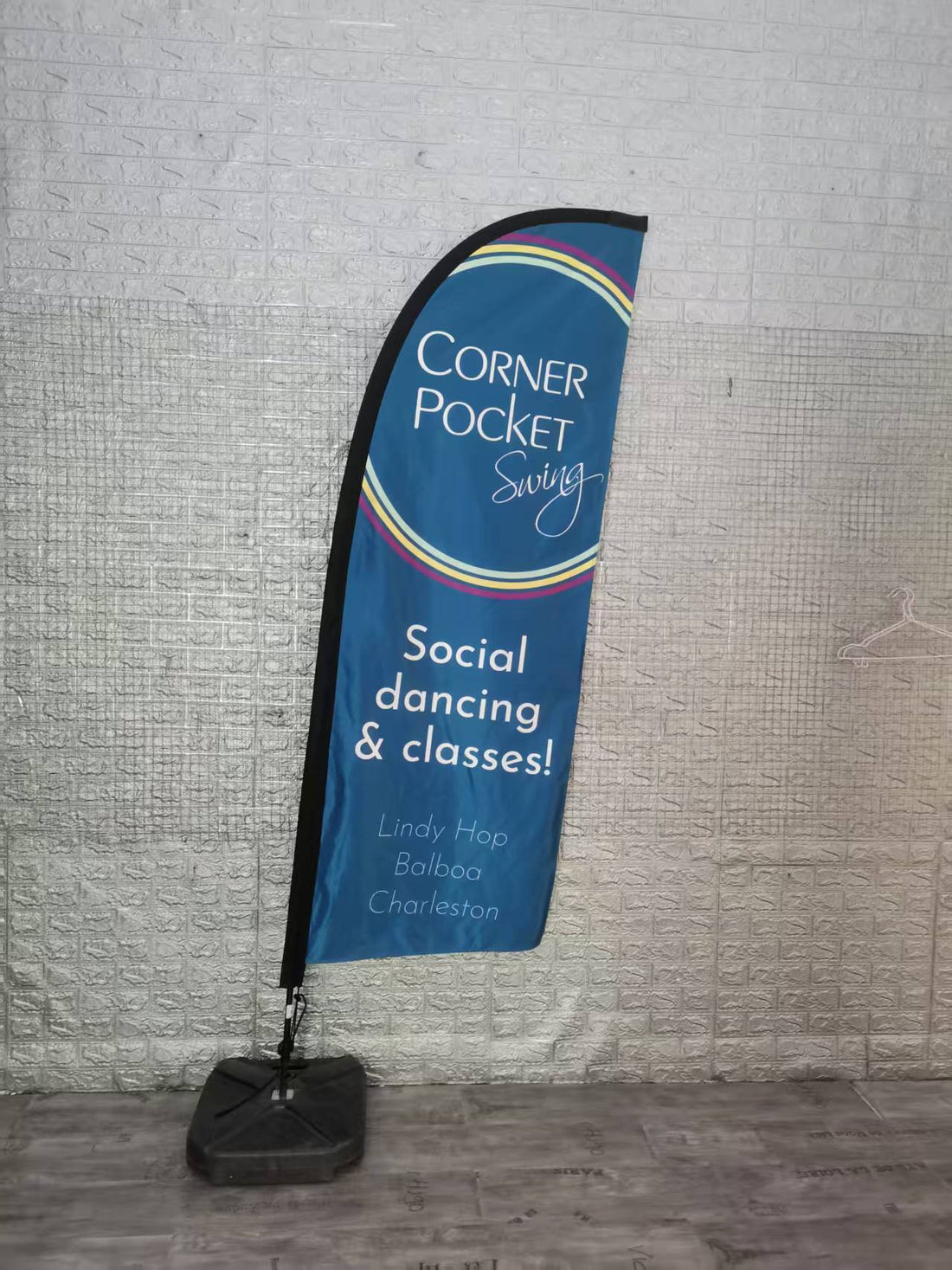 High-quality custom feather flag positioned at the entrance of a wellness center, prominently showcasing business branding and special offers to passing customers.