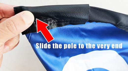 Sliding a custom teardrop banner onto a banner pole with reinforced leather sleeve for durability and long-lasting advertising flags setup