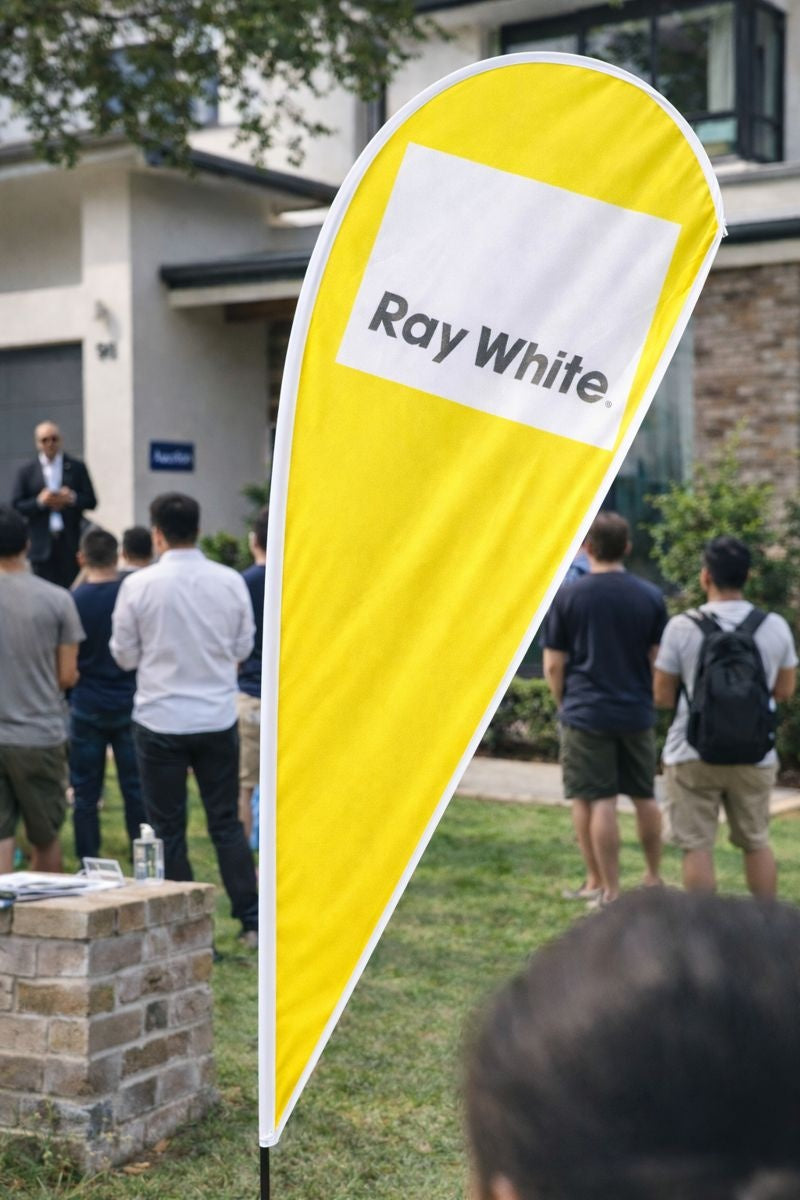 Real estate auction signage featuring custom teardrop banners and flag banners