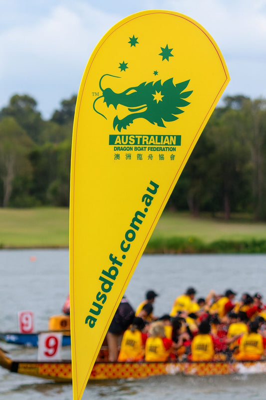 Australian Dragon Boat Federation teardrop banner displayed beside dragon boat race event on water